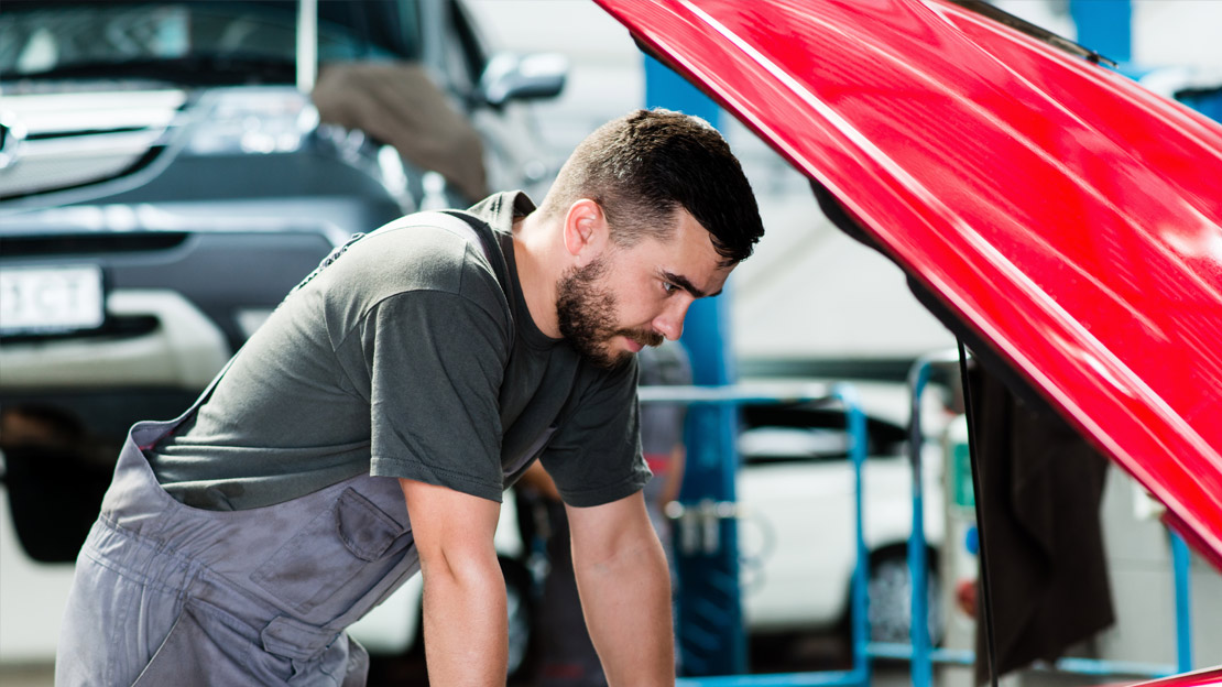 Serwisant sprawdzający stan auta - otwarta maska przednia auta